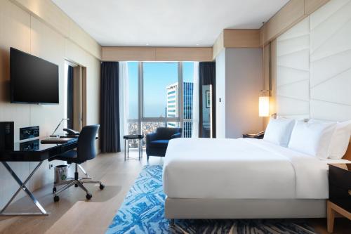 a hotel room with a large bed and a desk at Wyndham Grand Istanbul Levent Hotel & Conference Center in Istanbul