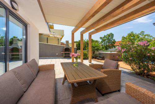 a patio with a couch and a wooden table at Relax Derossi 2 in Crikvenica