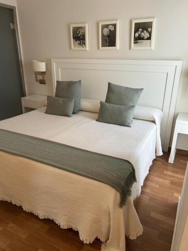 a bedroom with a large bed with two pillows at Hostal Plaza in Marmolejo
