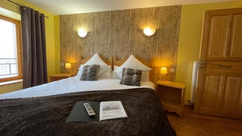une chambre d'hôtel avec un lit avec un livre dessus dans l'établissement Auberge du Couvige, à Le Bouchet-Saint-Nicolas