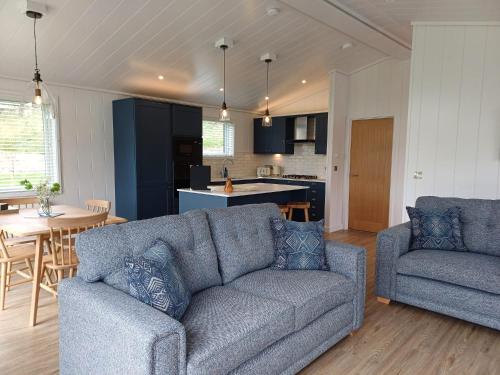 a living room with a couch and a kitchen at Falls Park in Ingleton 