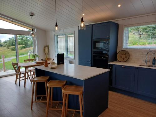 a kitchen with blue cabinets and a table and chairs at Falls Park in Ingleton 