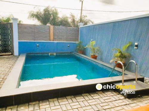 ein Swimmingpool vor einem blauen Gebäude in der Unterkunft Chic house with pool in Kribi