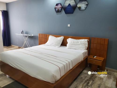 ein Bett mit weißen Laken und Kissen in einem Zimmer in der Unterkunft Chic house with pool in Kribi