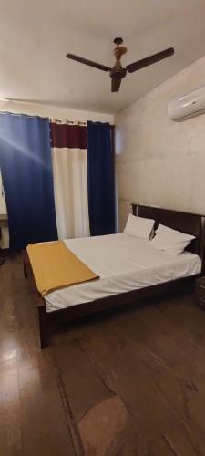a bed in a room with a ceiling fan at The Hills Studio Appartment in Tiruvannāmalai