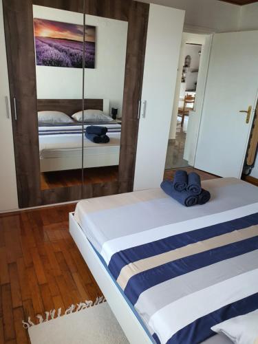 a bedroom with two beds and a mirror at Kuća za odmor SeaHouse in Karlobag