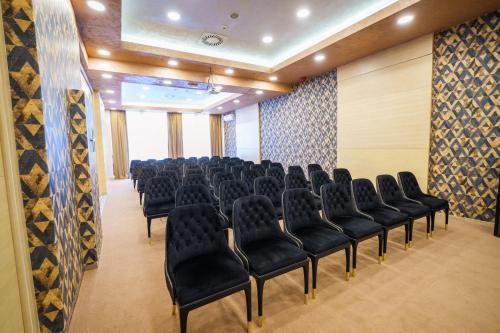 a conference room with black chairs in a room at Hotel Monogram Park in Ruma