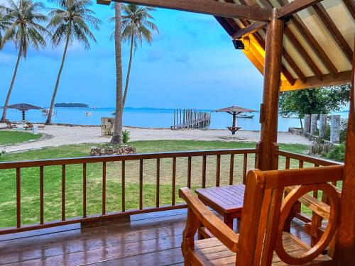 a porch with a chair and a view of the beach at Arys Lagoon Bungalow & Hotel in Karimunjawa