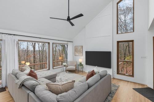 a living room with a large couch and a flat screen tv at Dream Retreat with Hot Tub, FirePit, Grill and only 15 min to Downtown Chattanooga in Signal Mountain