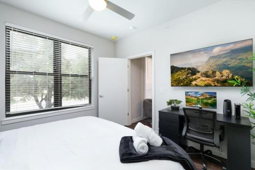 Un dormitorio con una cama y un escritorio y una ventana. en Chic 1BR w Gym & Parking Near Rvrwalk & Dome, en San Antonio