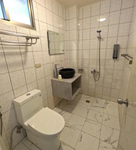 a white bathroom with a toilet and a shower at 綠島玉米-潛水住宿 Diveholix Homestay in Green Island