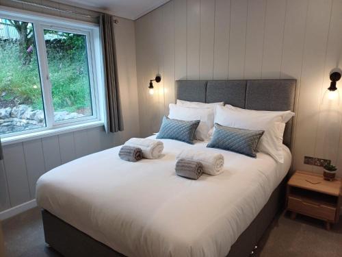 a bedroom with a large bed with three pillows on it at Falls Park in Ingleton 