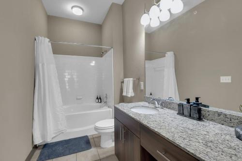 a bathroom with a sink and a toilet and a shower at Chic 2BR- Pool,Gym,Pkng,Near BOK Ctr&Arts Dstrct in Tulsa