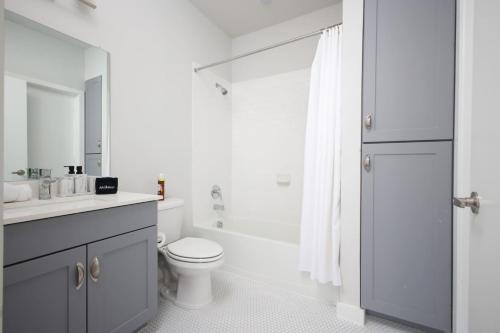 Un baño con inodoro, lavabo y ducha. en Stylish 2BR w Pool,Gym,Prking-Near Rvrwalk & Dome, en San Antonio