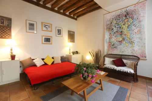 a living room with a red bed and a couch at My Trip in Paris - Argout in Paris