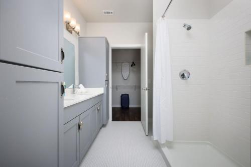 une salle de bain blanche avec un lavabo et une douche dans l'établissement Cozy 2BR-w Parking, Near Rvrwalk, Dome & Conv Ctr, à San Antonio