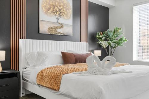 a bedroom with a white bed with a tree on it at Modern 1BR w Parking, Near Temple Square & Delta Center in Salt Lake City