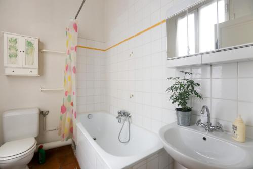 une salle de bain avec toilettes, baignoire et lavabo dans l'établissement My Trip in Paris - Argout, à Paris