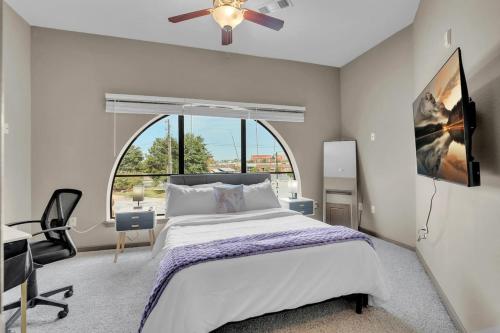 a bedroom with a bed and a large window at Cozy 1BR- Pool,Gym,Pkng,Near BOK Ctr&Arts Dstrct in Tulsa