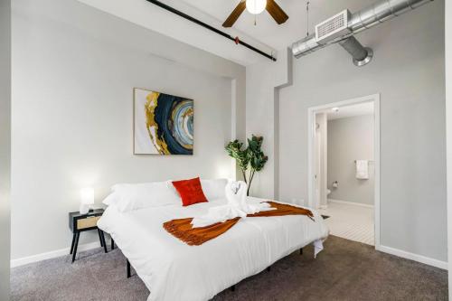 a white bedroom with a large bed and a ceiling fan at Chic 2BR-Parking, Rooftop,Near Arrowhd & TMobile in Kansas City