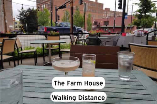 a table with two glasses of water and a sign saying the farm house walking distance at Classy 2BR-Parking, Rooftop,Near Arrowhd & TMobile in Kansas City
