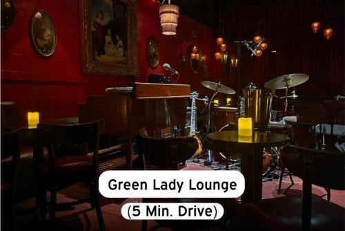 a room with a red wall with tables and drums at Classy 2BR-Parking, Rooftop,Near Arrowhd & TMobile in Kansas City