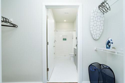 Baño blanco con puerta que conduce a un pasillo en 1BR Escape-w Parking, Near Riverwalk & Conv Ctr, en San Antonio