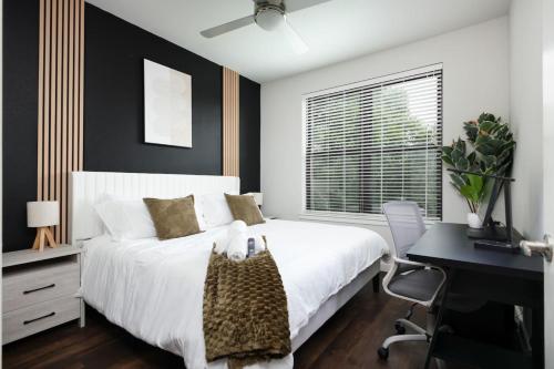une chambre avec un lit blanc avec un bureau et une fenêtre dans l'établissement 2BR Urban Escape-w Prkng, Near Rvrwalk & Conv Ctr, à San Antonio