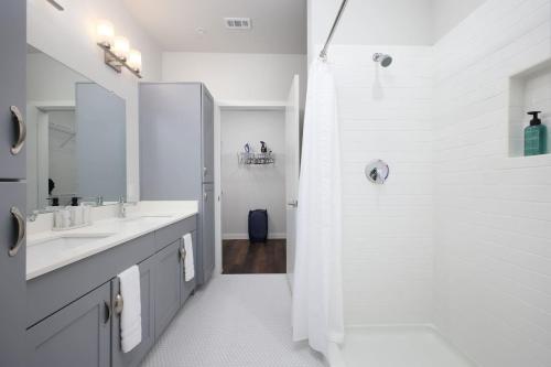 une salle de bain blanche avec deux lavabos et une douche dans l'établissement Chic 2BR-w Parking, Near Rvrwalk, Dome & Conv Ctr, à San Antonio