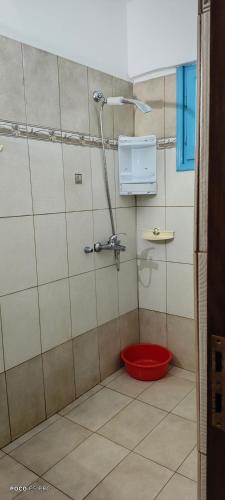 a shower with a red bucket in a bathroom at Studios by Climbing House in Panormos Kalymnos
