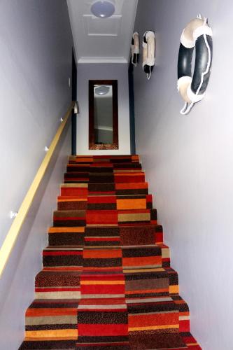a stairway with a colorful rug on it at Beachlander Self-Contained Holiday Apartments in Coffs Harbour