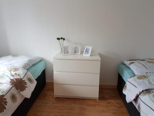 a bedroom with two beds and a white dresser with two beds at Haus-Selma in Lüneburg