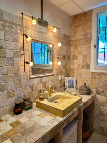 a bathroom with a wooden sink and a mirror at Charmante maison provençale in Les Taillades