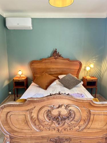 a bedroom with a wooden bed with two night stands at Charmante maison provençale in Les Taillades
