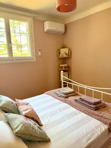 a bedroom with a bed with pillows and a window at Charmante maison provençale in Les Taillades