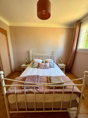 a bedroom with a large bed with two pillows at Charmante maison provençale in Les Taillades
