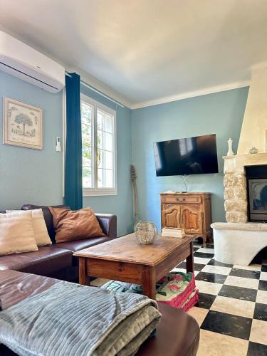 a living room with a couch and a table at Charmante maison provençale in Les Taillades