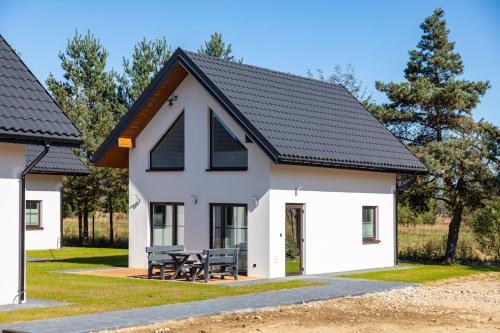 a white house with a black roof at Hotel Perła Dunajca in Czarny Dunajec