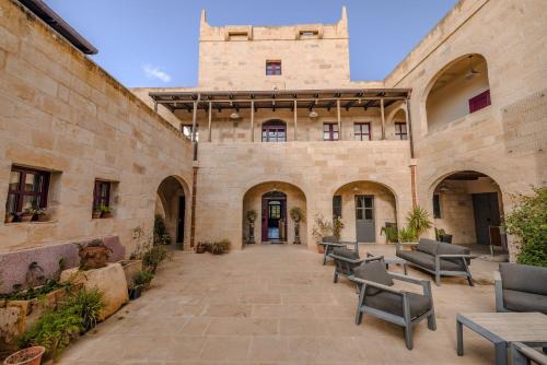 a courtyard of a building with benches in front of it at Mulberries in Żabbar