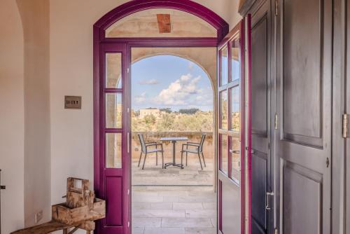an open door to a patio with a table and chairs at Mulberries in Żabbar