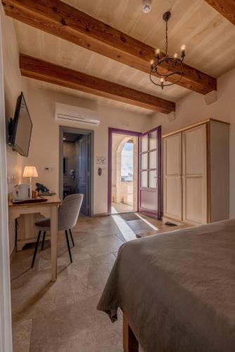 a bedroom with a bed and a desk and a table at Mulberries in Żabbar