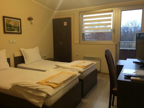 a room with two beds and a desk with a computer at Prenociste Gazela in Pirot
