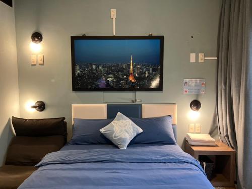 a bedroom with a bed with a tv on the wall at 樂客背包旅棧 Local Backpacker Hostel in Tainan