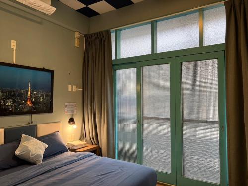 a bedroom with a bed and two large windows at 樂客背包旅棧 Local Backpacker Hostel in Tainan