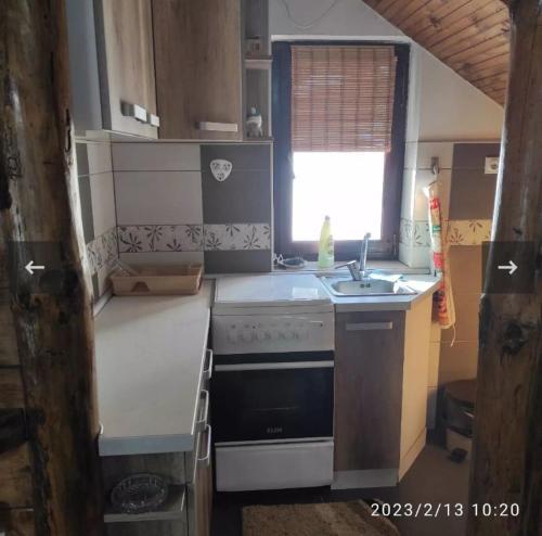 a small kitchen with a sink and a stove at Apartmani Maljković in Knjazevac.