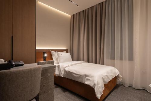 a hotel room with a bed and a desk and a bed sidx sidx sidx sidx at Garni Hotel Galeria in Banja Luka