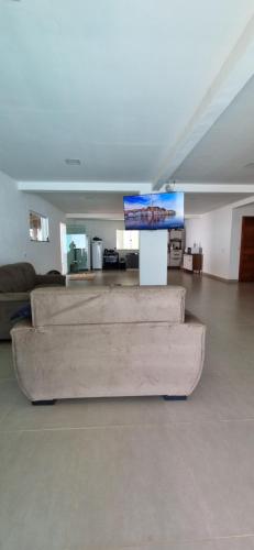 a living room with a couch and a flat screen tv at Casa saquaira in Praia dos Algodões