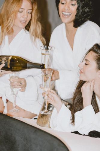 a woman pouring a glass of wine with two girls at The Chesterton Hotel in Bicester