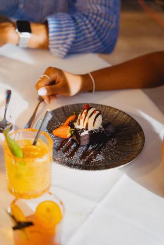 a person holding a plate with a dessert on a table at The Chesterton Hotel in Bicester