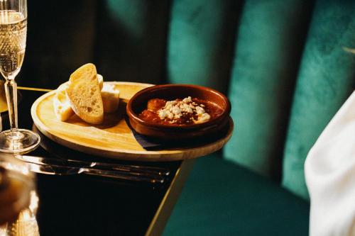a plate with a bowl of food and a glass of wine at The Chesterton Hotel in Bicester